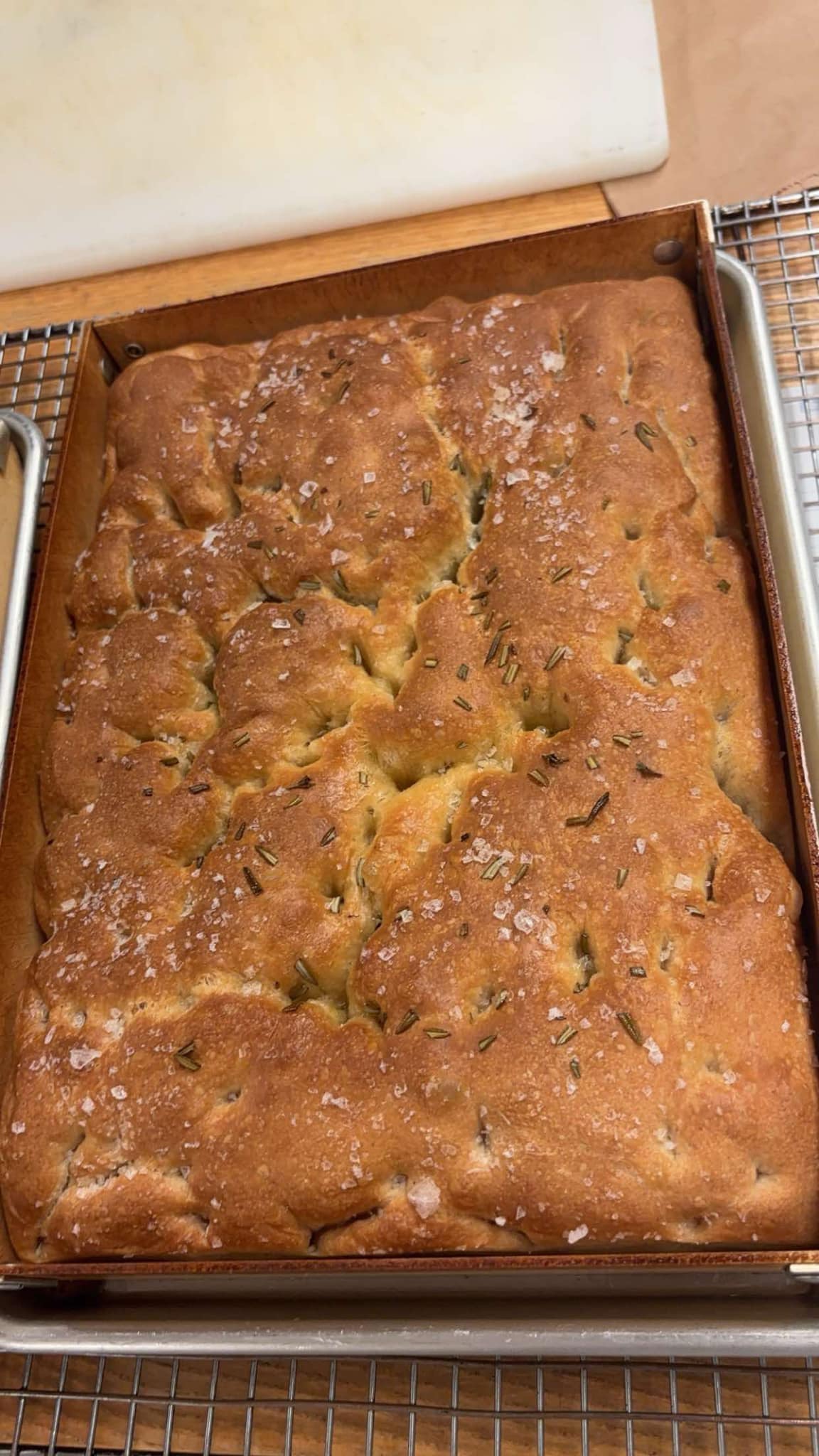 Rosemary sea-salt focaccia, golden top, in a quarter sheet pan