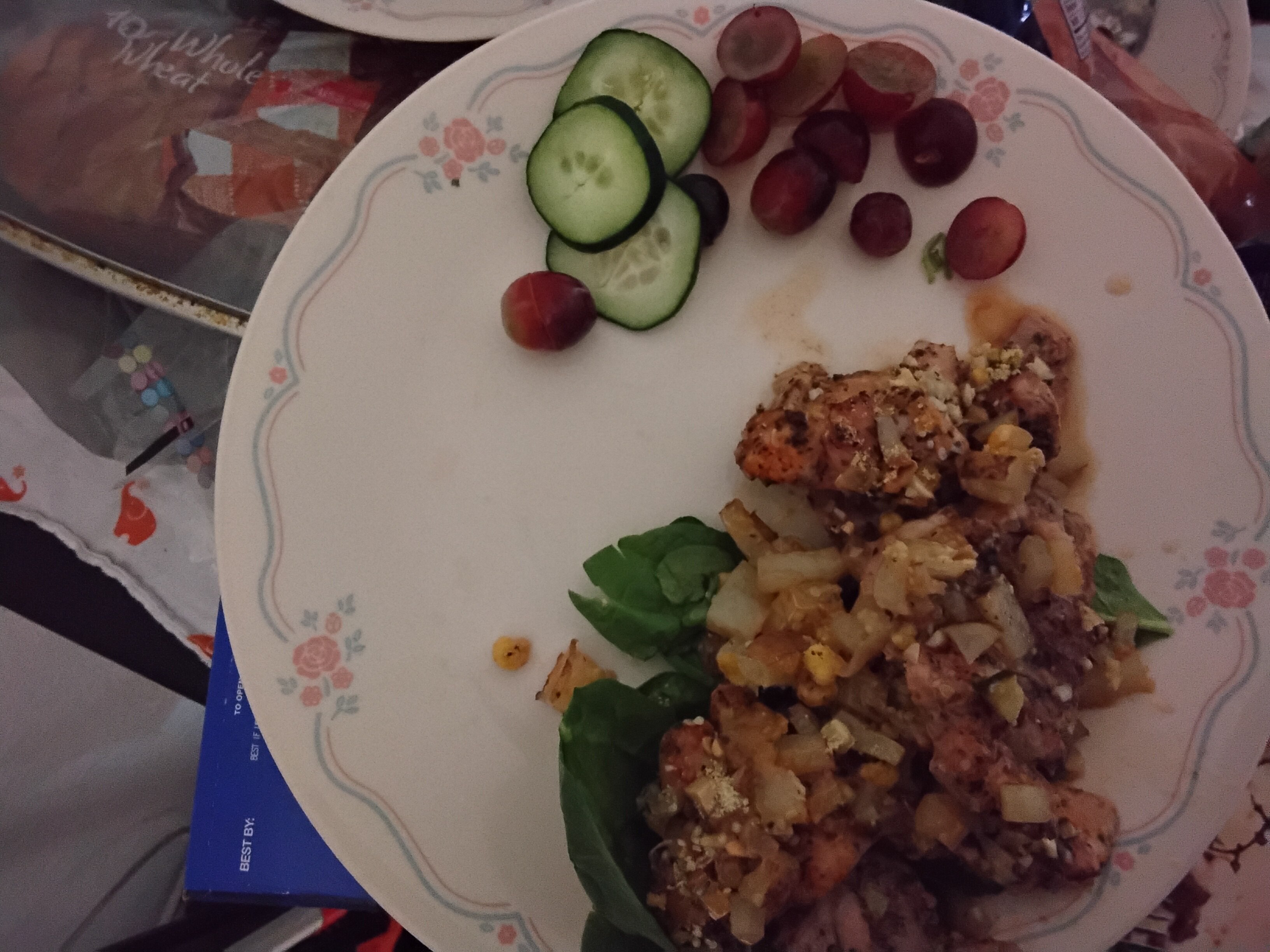Plated herb-crusted chicken with hash, cucumbers, grapes and spinach
