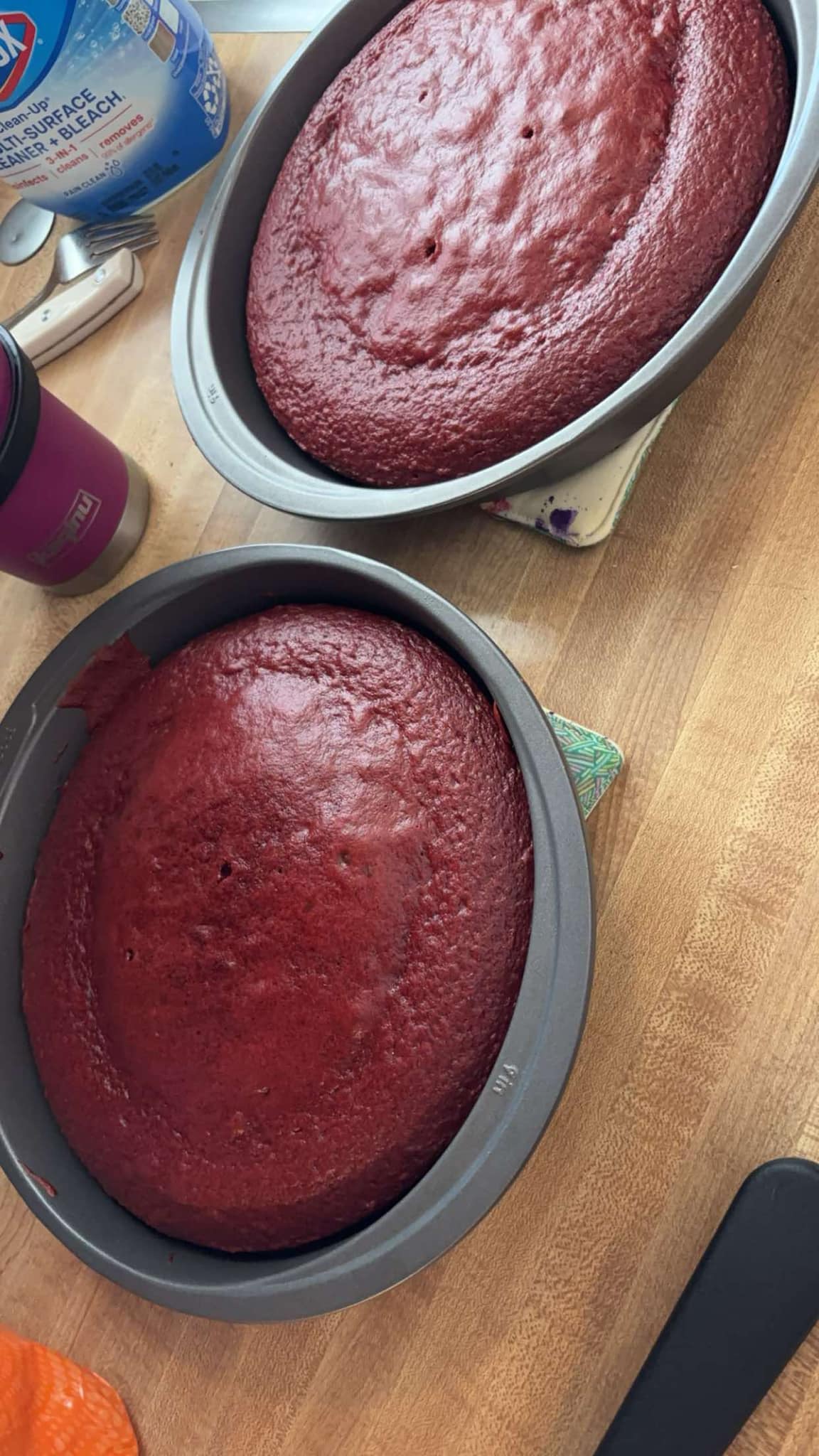 Two red velvet cake layers, freshly baked in round and oval pans